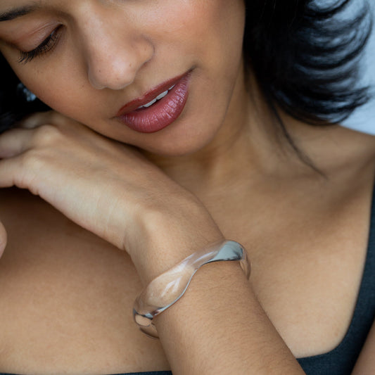 model looks down at wavy clear cuff bracelet